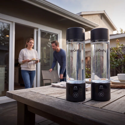 Two black PIURIFY Hydrogenator hydrogen water bottles on a patio table